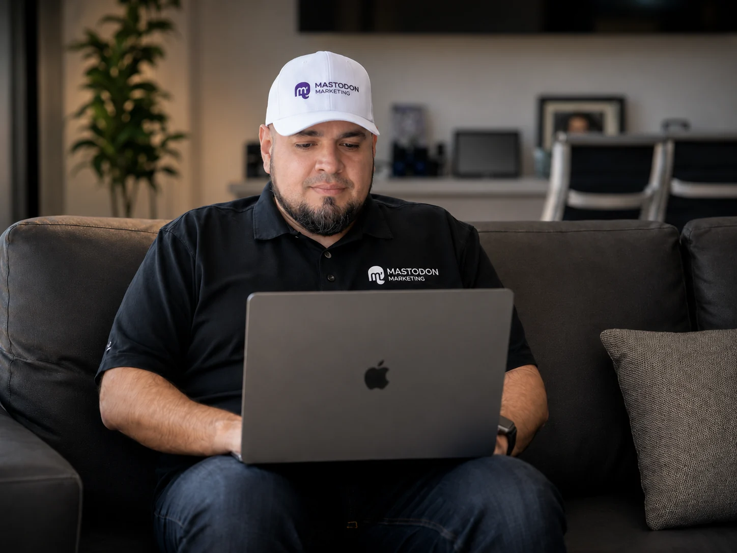 Alex Rocha working from a laptop at Mastodon Marketing's Pearland Texas office wearing a Mastodon Marketing branded polo